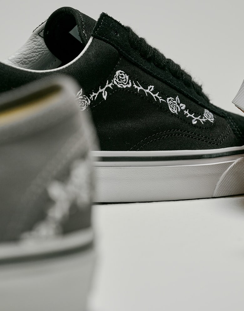 Plan rapproché du motif floral blanc brodé sur un Old Skool noir.