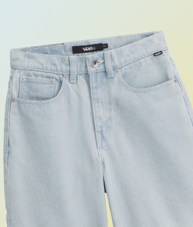 A pair of stonewash blue Kids Sirelle Denim Puddle Pants against a yellow and blue background.