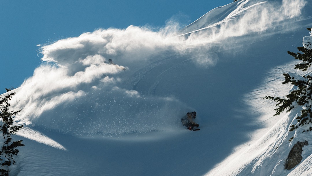 A snowboarder riding powder.