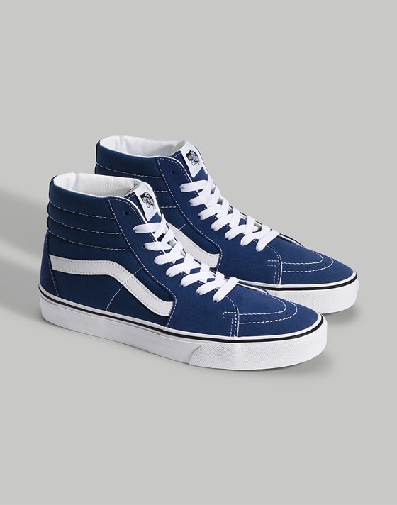 A pair of navy and white Sk8-Hi on the floor of a photography studio.