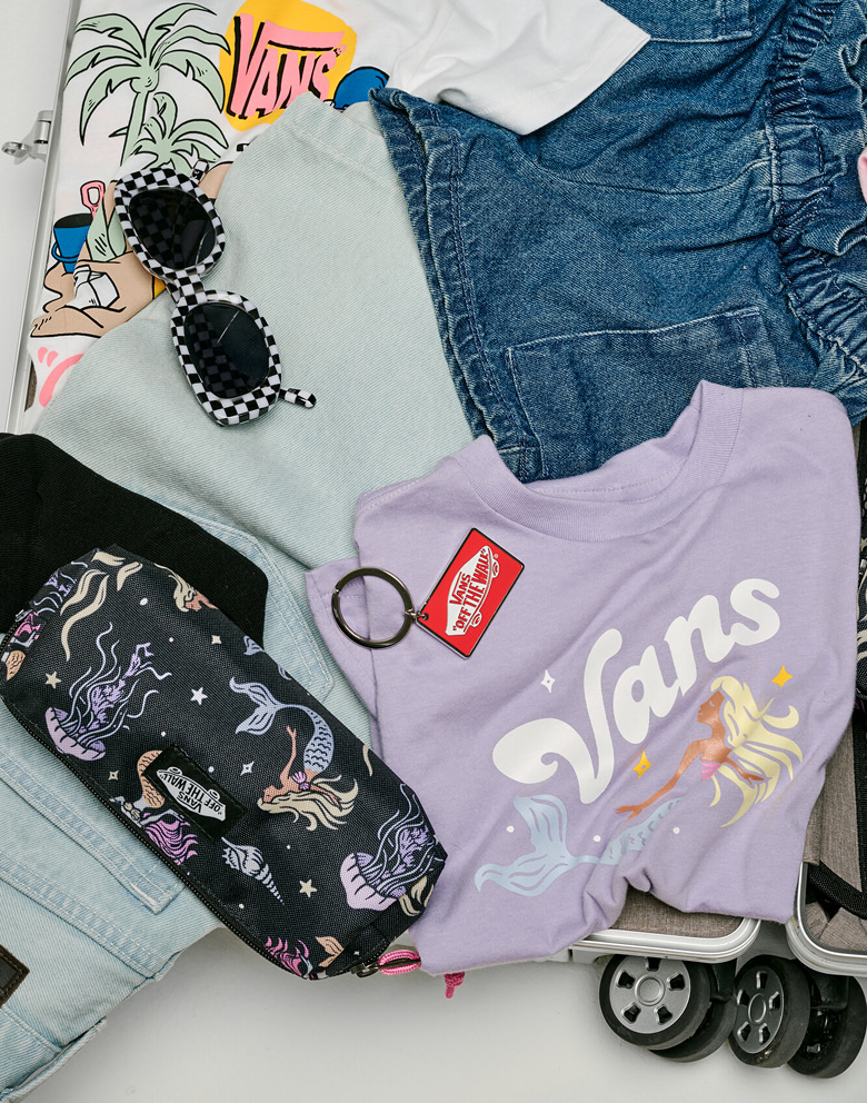 A variety of tees, boardshorts, socks, and Vans shoes in a rolling suitcase for spring break.