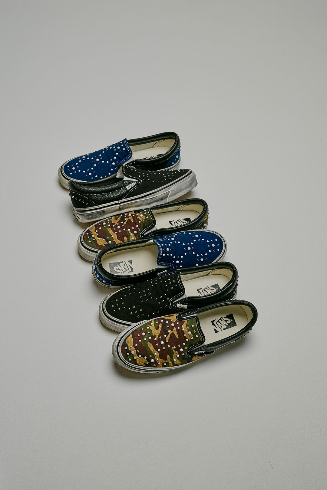 3 pairs of Classic Slip-On Pearlized shoes arranged in a line.