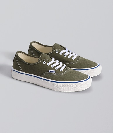 A pair of mossy olive green Skate Authentic Shoe on the floor of a photography studio.