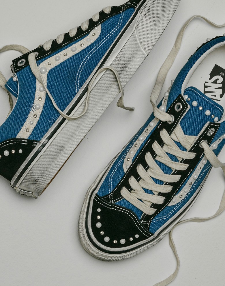 A pair of blue and black Old Skool Pearlized on the floor of a photography studio.