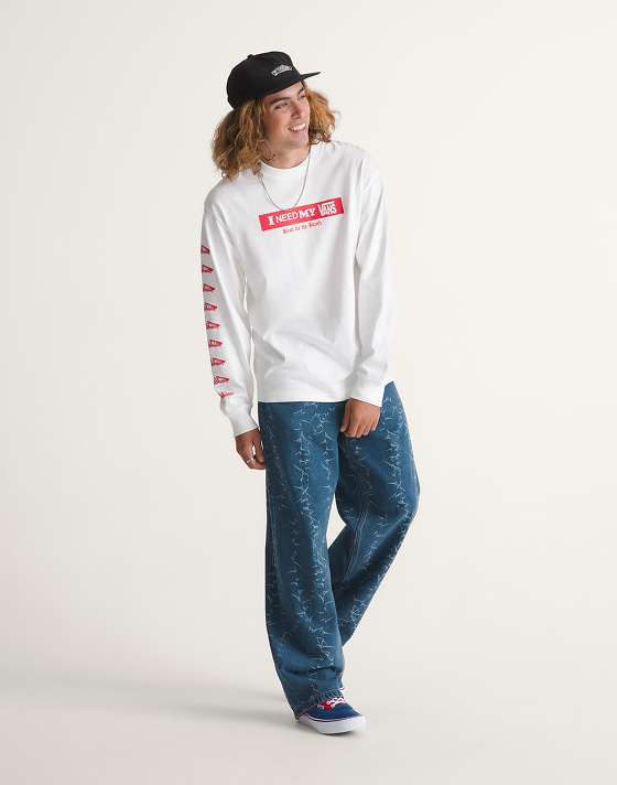 A young man posing in a photography studio wearing I Need My Long Sleeve T-Shirt and vintage indigo blue Check-5 Baggy Denim Pants.