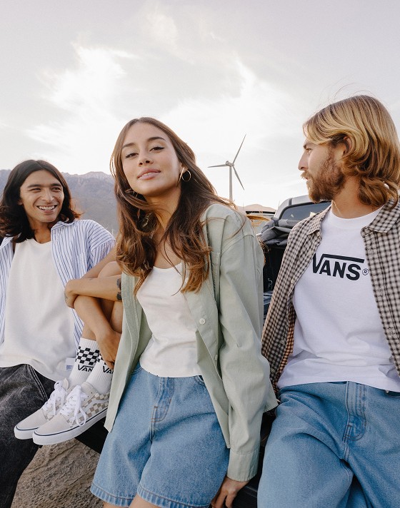 A group of friends sit on the bed of a truck in new Vans clothes.