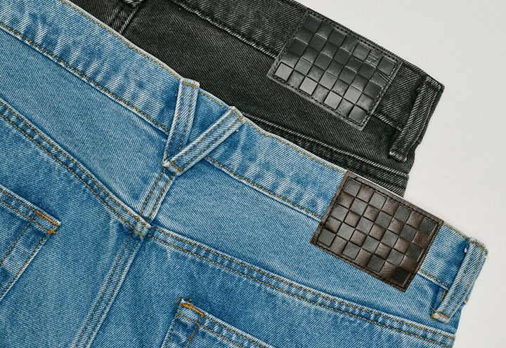 Two pairs of Check-5 Baggy Denim Pants stacked on top of each other.