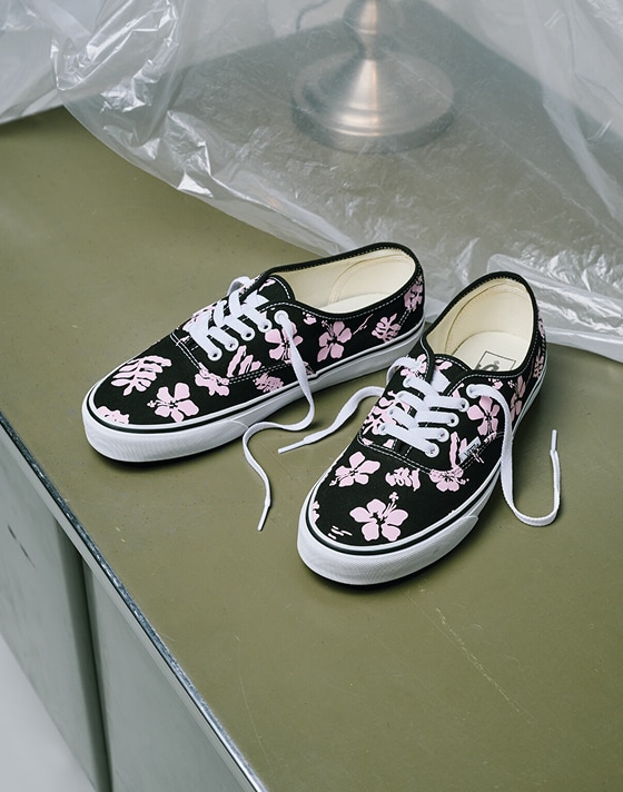 A pair of black and pink floral Authentic shoes from the Worn Loud Authentic Legacy drop on a desk.