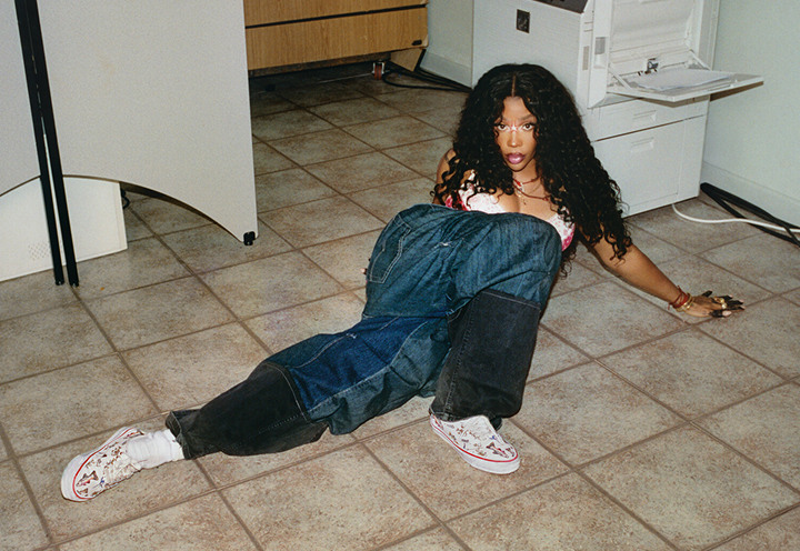 Singer and Vans Artistic Director SZA lying on the floor of an office and baggy jeans wearing Authentic shoes.