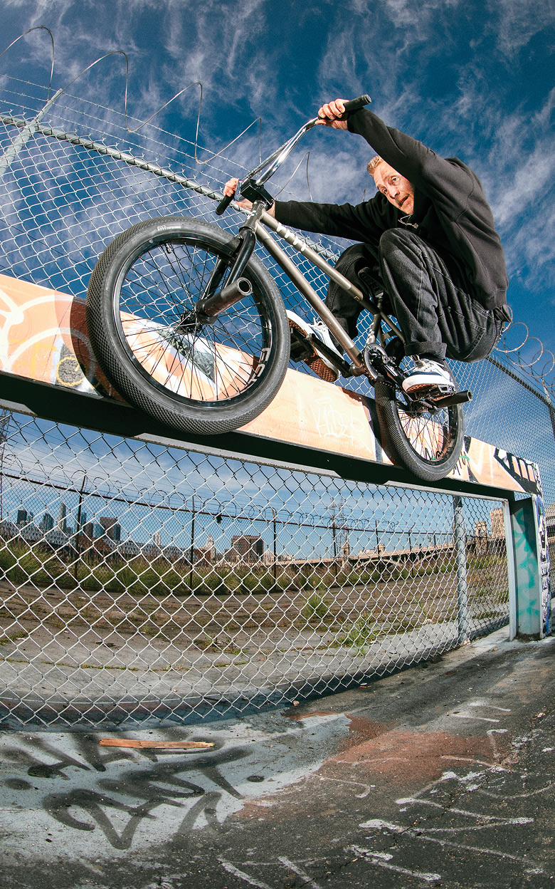 Vans BMX Team Rider Kilian Roth grinds a rail next to a cyclone fence wearing the Skate Era WaffleCup.