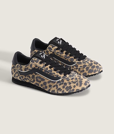 A pair of leopard orange and black Super Lowpro shoes on the floor of a photography studio.