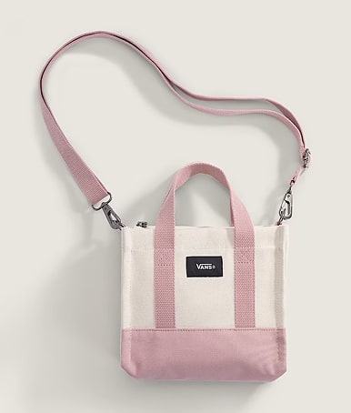 A white and misty mauve pink Lil Pergs Tote Bag on the floor of a photography studio.
