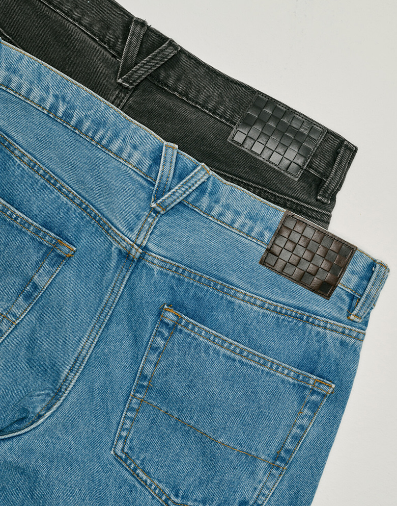 Two images: two pairs of Check-5 Baggy Denim Pants stacked on top of each other and the other of a young man wearing the stonewash blue colorway.