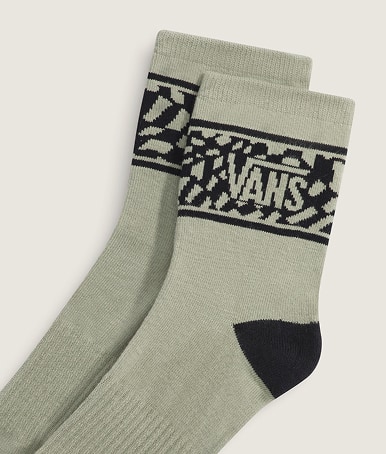 Close-up on a pair of soft sage green Warp Check Half Crew Socks in a photography studio.