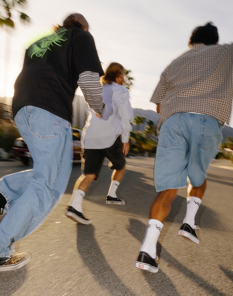 A blurry image of three young men running down the street in Vans shoes and clothes at dusk.