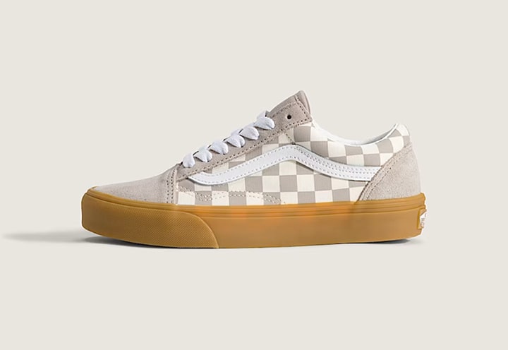 The side profile of a Gum Checkerboard Mushroom Brown Kids Old Skool Shoe in a photography studio.
