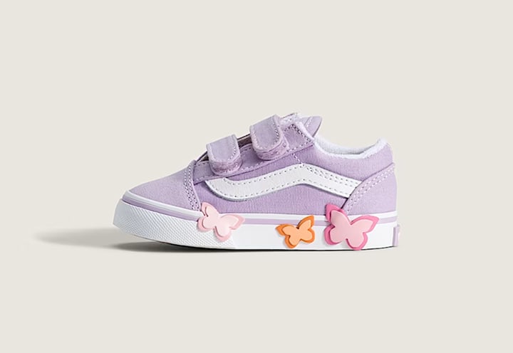 The side profile of a soft orchid purple Toddler Old Skool V Shoe with butterflies on the side in a photography studio.