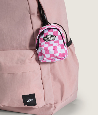 Plan rapproché d’une breloque sac à dos miniature accrochée à un mini sac à dos Old Skool rose mauve brumeux.