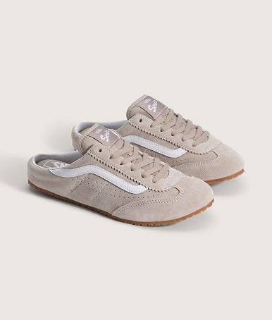 A pair of taupe beige Super Lowpro Mules on the floor of a photography studio.