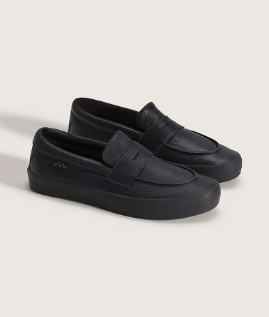A pair of black Skate Loafers on the floor of a photography studio.