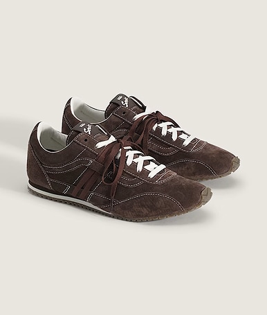 A pair of white and brown Premium Super Lowpro Trainers on the floor of a photography studio.