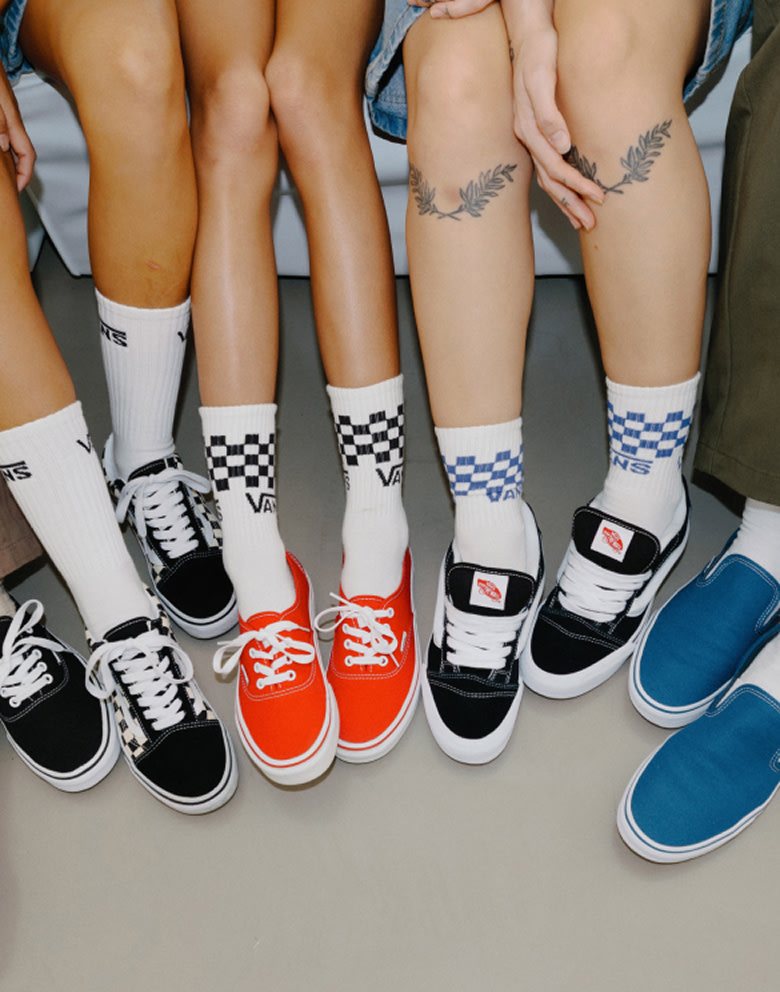 A group of friends sitting in a circle wearing Vans Icons in different colorways.