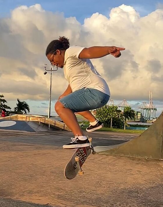 A young man does a kickflip at a skatepark wearing black and white Authentic.