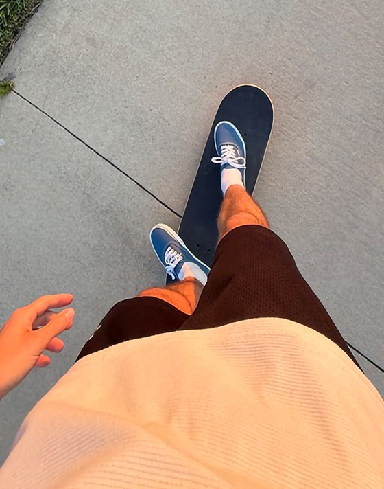 An overhead shot of a young man on a skateboard wearing blue Authentic shoes.