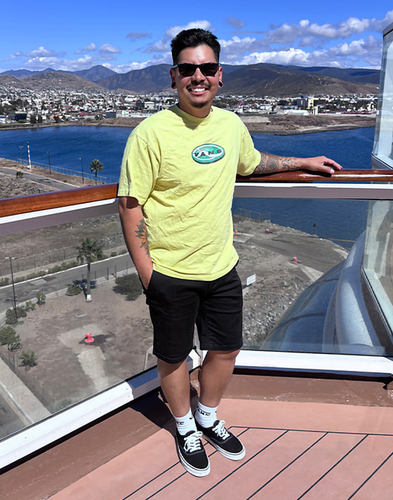 A young man poses on a balcony wearing black and white Authentic with white crew socks.