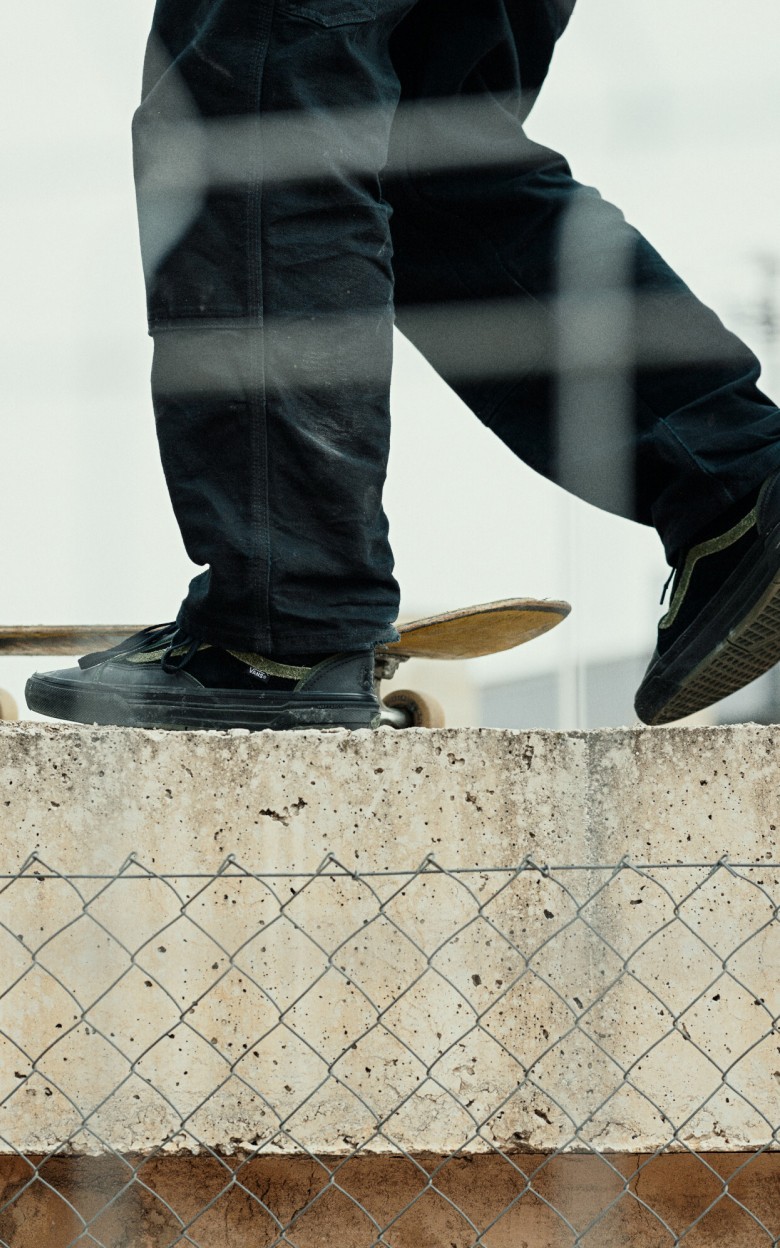 Close-up on a skater walking to his board wearing Skate Old Skool WaffleCup™in Willow Voges Fernandes Green and Black.