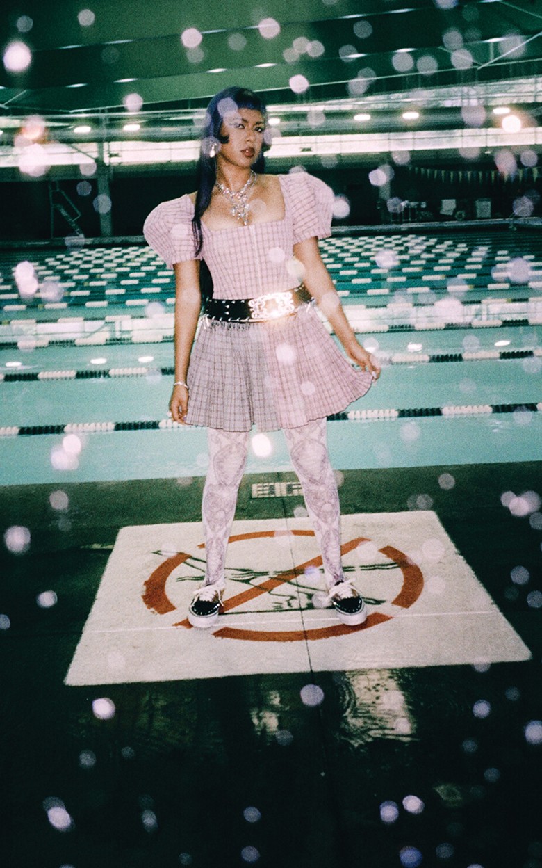 Singer Ecca Vandal poses next to an indoor swimming pool wearing Authentic shoes with spikes and mohair from the Worn Loud collection.