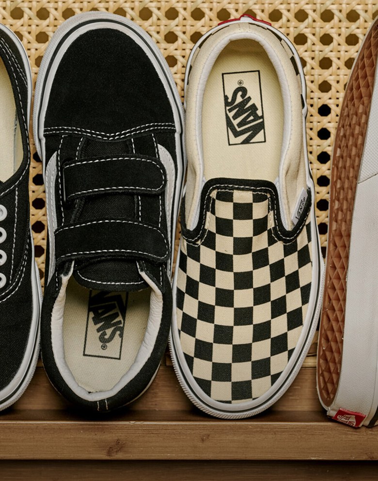 An overhead shot of black and white kids’ Icons stacked on a wicker chair.
