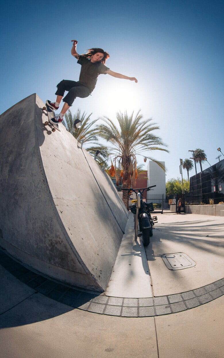 A fisheye shot of a skater riding down a concrete wall in black and red Skate Era shoes.