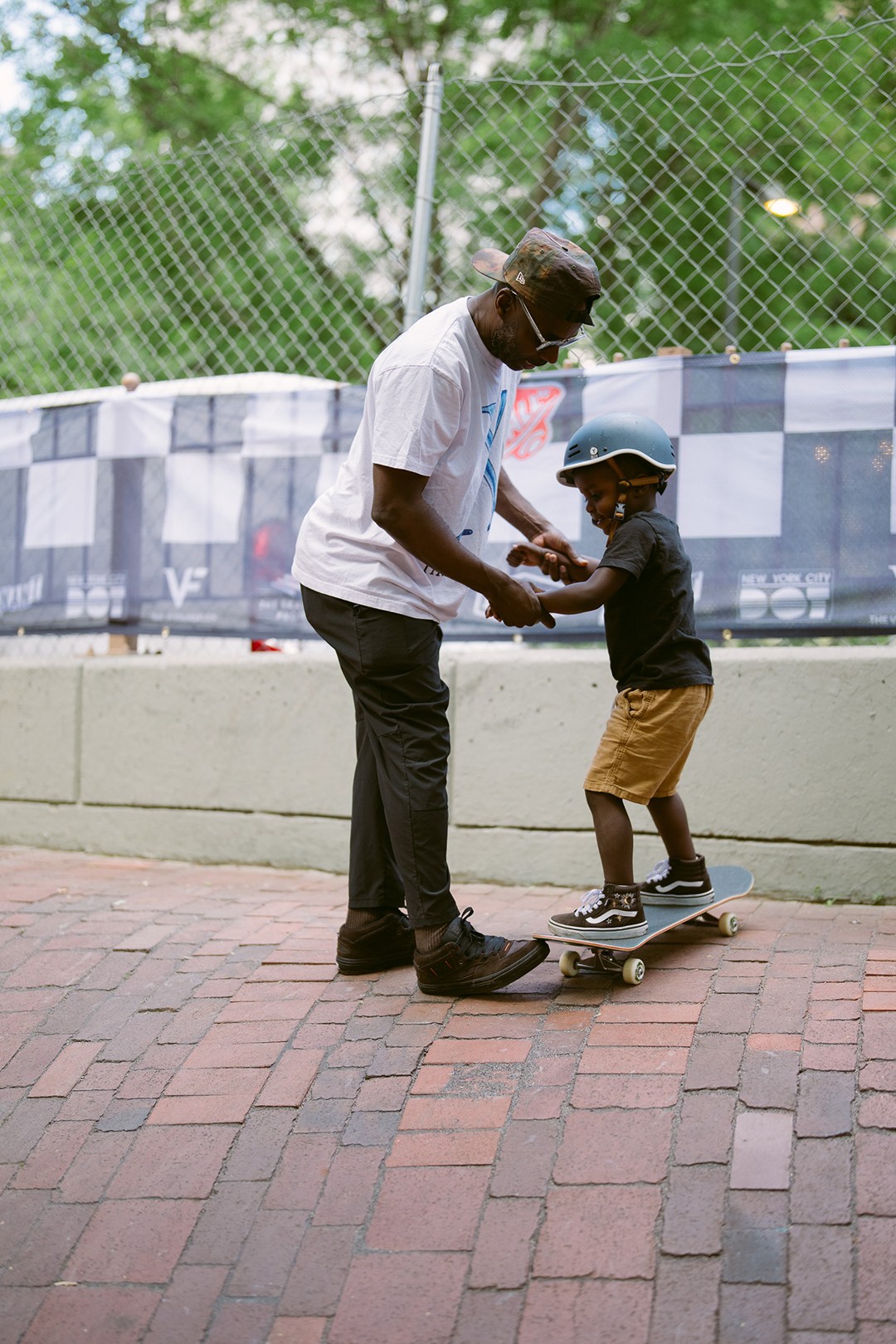 A father teaching his son how to ride a skateboard at the Vans Go Skateboarding Day Event 2026