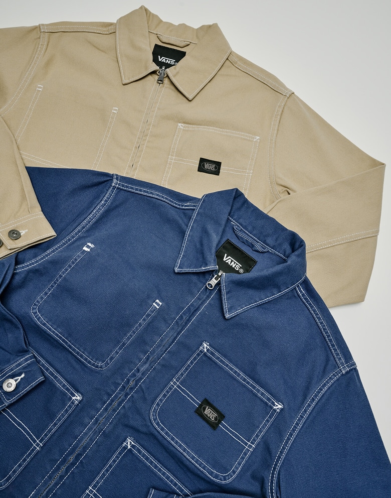 Medium shot of the Emily Boxy Work Wear Jacket in tan and blue laying on the floor of a grey photography studio.
