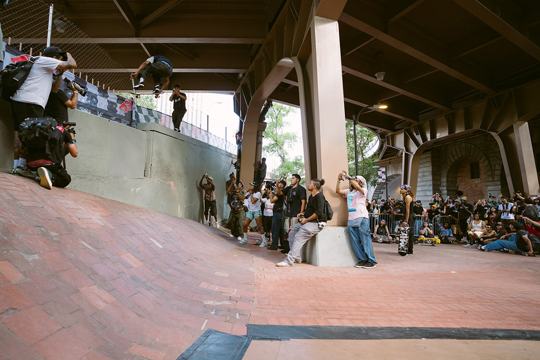 A group of people watch a skateboarding athlete do a trick at the Vans Go Skateboarding Day Event 2026