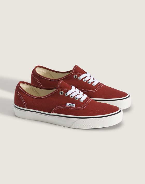 A pair of burgundy Authentic on the floor of a photography studio.