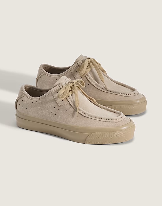 A pair of light brown Premium SF Moc Low Shoes on the floor of a photography studio.