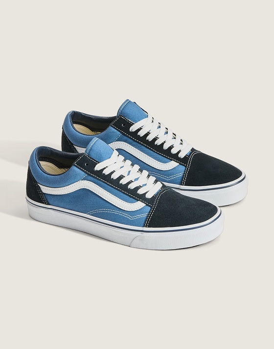 A pair of black and blue Old Skool on the floor of a photography studio.
