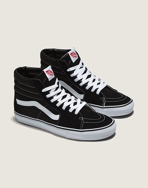 A pair of black and white Sk8-Hi on the floor of a photography studio.