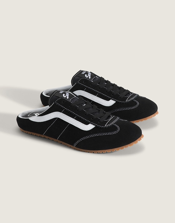 A pair of black and white Super Lowpro Mule on the floor of a photography studio.