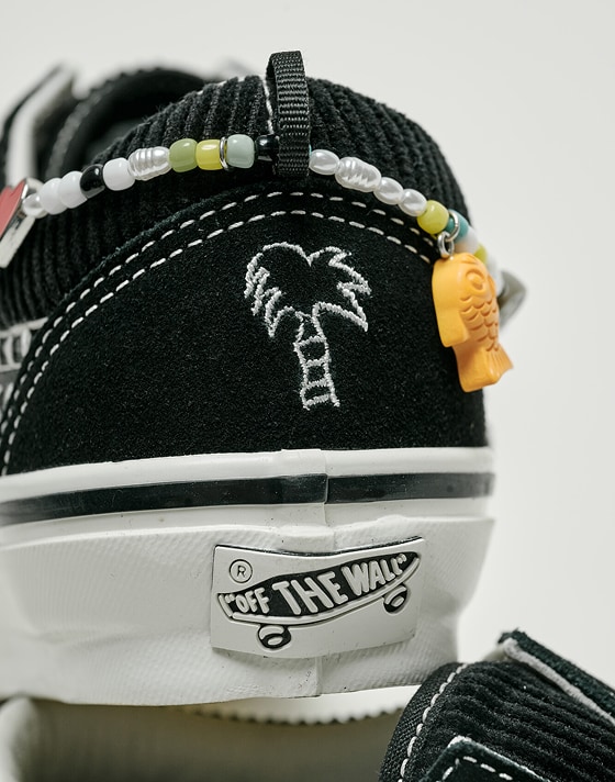 Close-up on the friendship bracelet and stitched palm tree on the black Premium Old Skool Cocona Shoe.