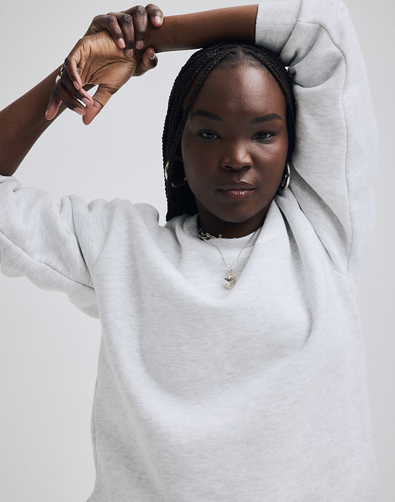 Close-up on a young woman wearing a white Salton Crew Sweatshirt.