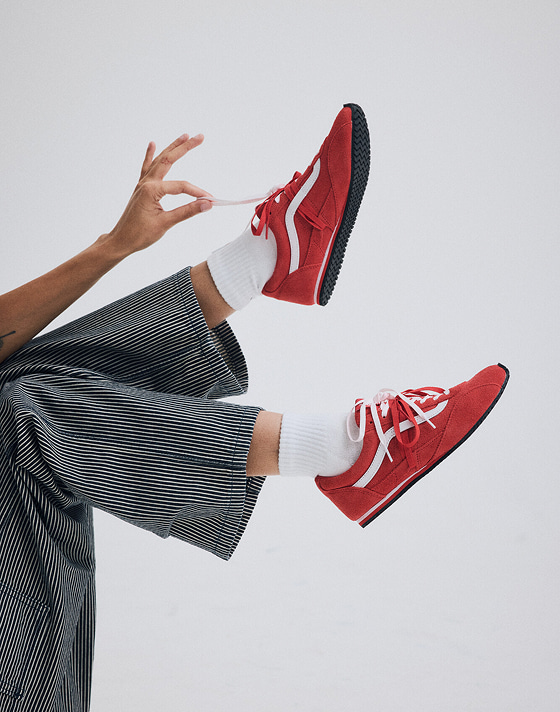 A young woman kicks her feet up in the red Super Lowpro.