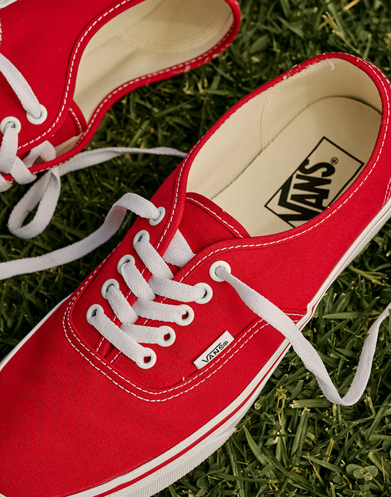 Close-up on a pair of red Authentic shoes on some grass.