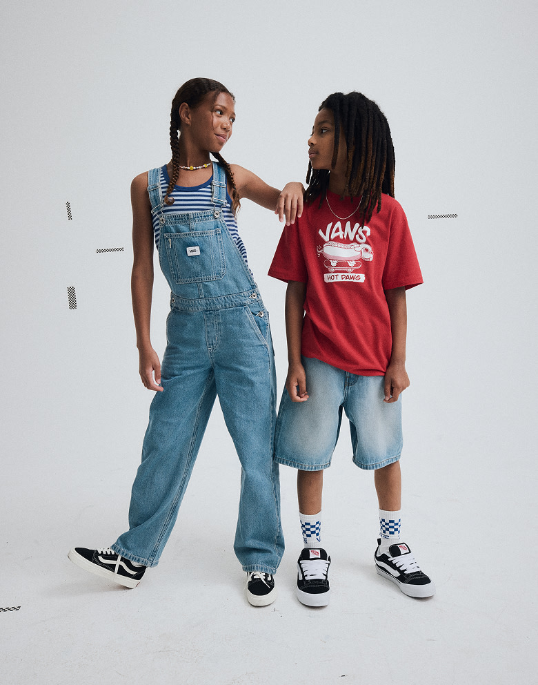 A young boy and girl pose together wearing Vans shoes and clothes in a a photography studio.
