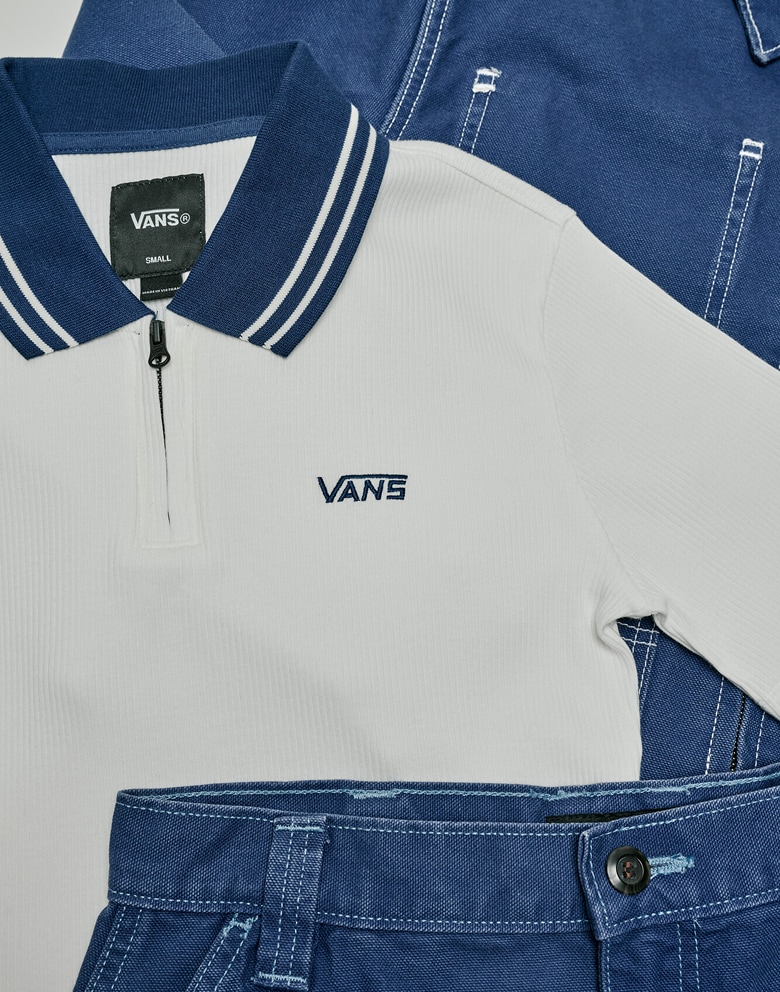 Top down shot of the Priscilla Polo Shirt in Egret White with blue jeans on top of it and a blue workwear jacket behind it.