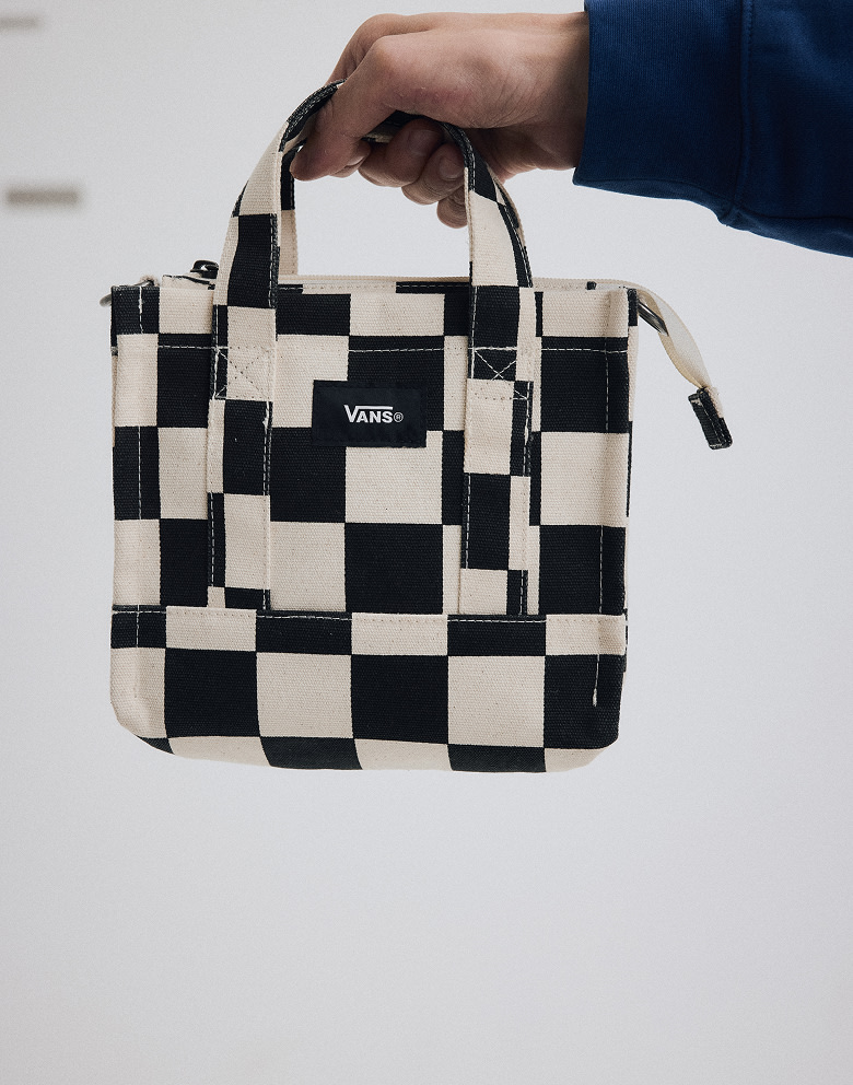 Close-up on someone holding a Checkerboard Lil Pergs Checkerboard Tote Bag in a photo studio.