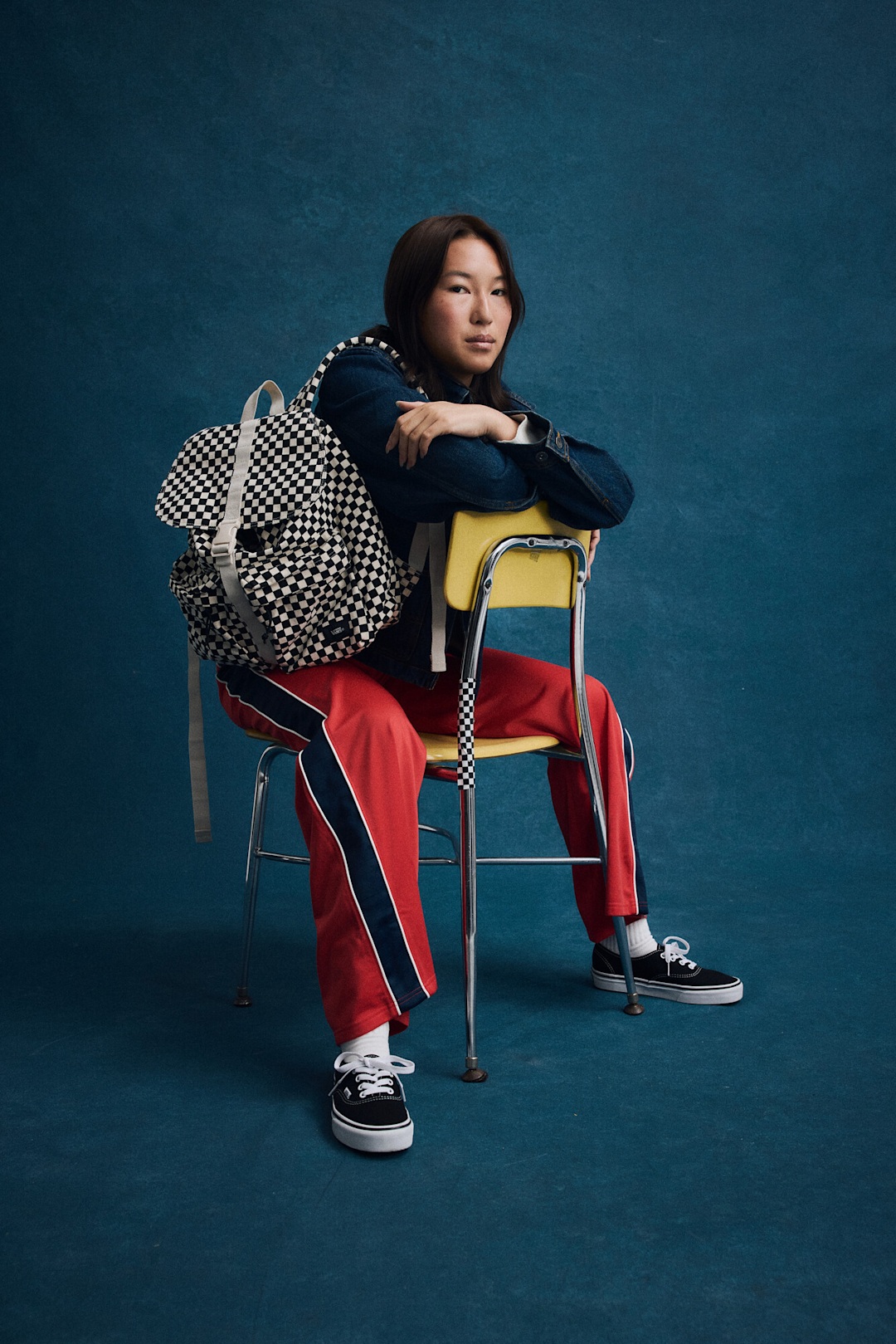 College kid sitting on a chair with Vans backpack