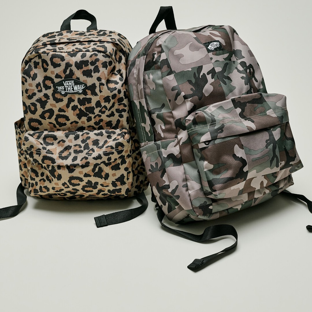 A studio shot of 2 back packs in cheetah print and camo